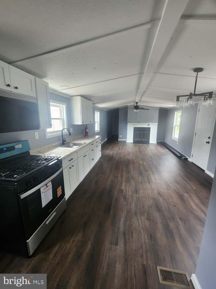 260 Marshall Mill Road, Unit 148 Franklinville, NJ 08322 - Photo 7 of 14 a kitchen with a stove wooden floor and a sink