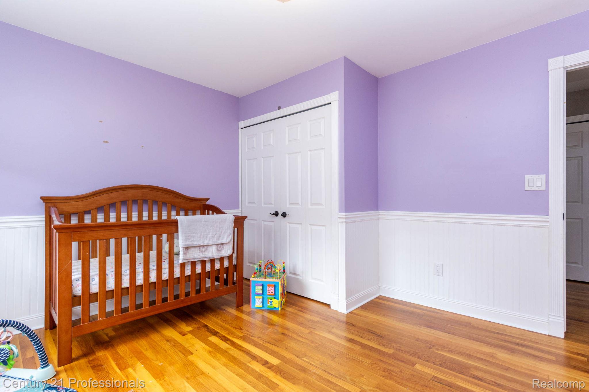 671 Bridgestone Drive Rochester, MI 48309 - Photo 34 of 50 Hardwood flooring throughout featuring white wainscoting and lavender-painted walls