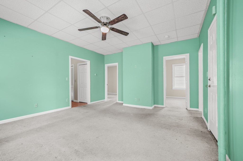 216 Grove Street Fall River, MA 02720 - Photo 18 of 26 a view of an empty room with a window and a ceiling fan