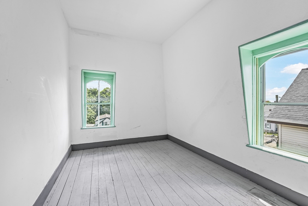 216 Grove Street Fall River, MA 02720 - Photo 24 of 26 an empty room with a window and wooden floor