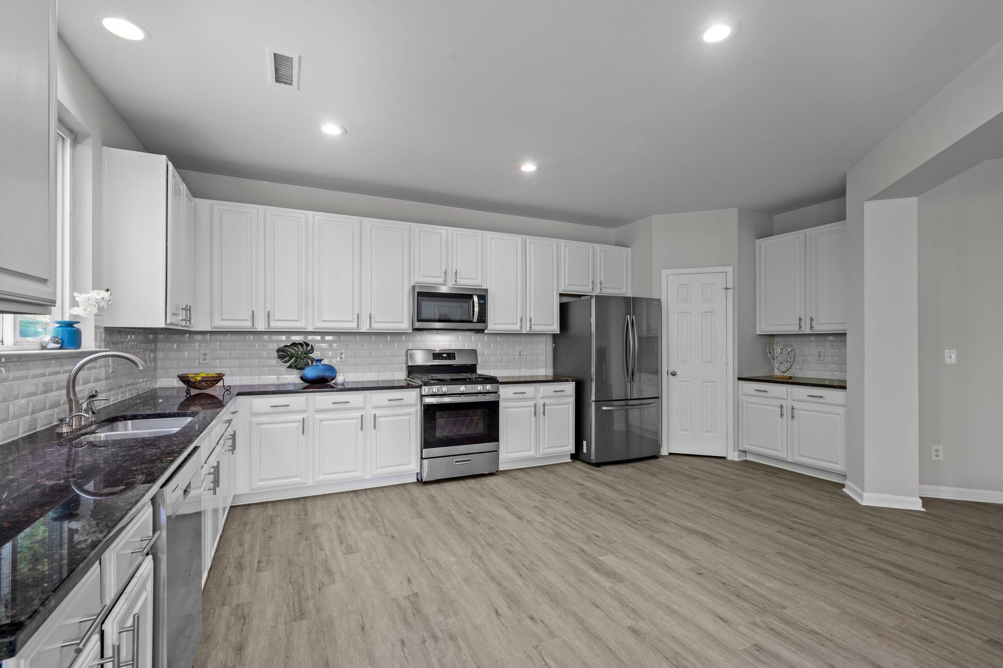 532 Emerald Downs Road Cary, NC 27519 - Photo 24 of 51 a kitchen with granite countertop white cabinets and stainless steel appliances
