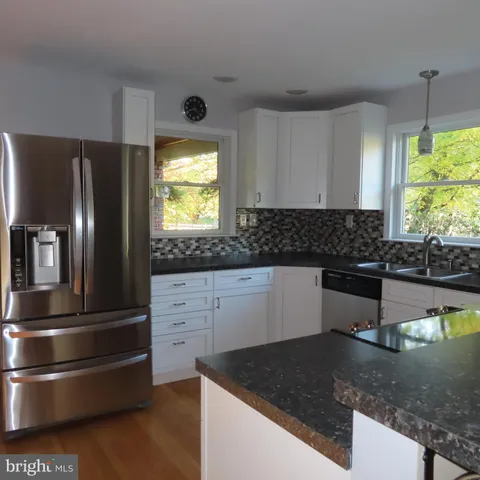 a kitchen with granite countertop a refrigerator and a sink