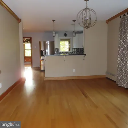a view of empty room with wooden floor and window