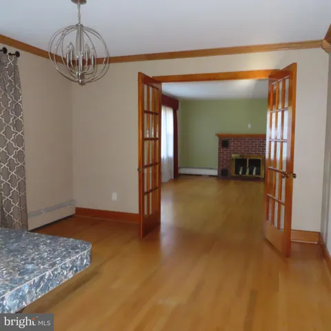 a view of a livingroom with wooden floor and a chandelier