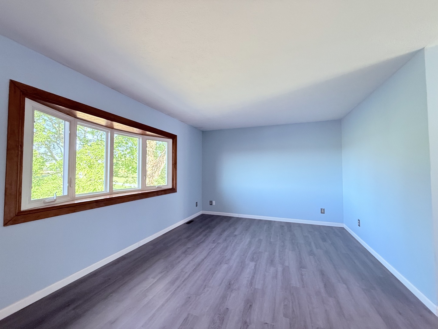 8824 Sunset Road Clinton, IL 61727 - Photo 4 of 24 an empty room with wooden floor and windows