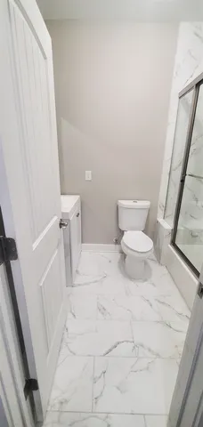 a bathroom with a toilet and a shower