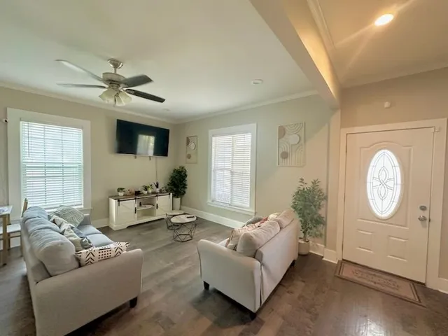 a living room with furniture a large window and a chandelier