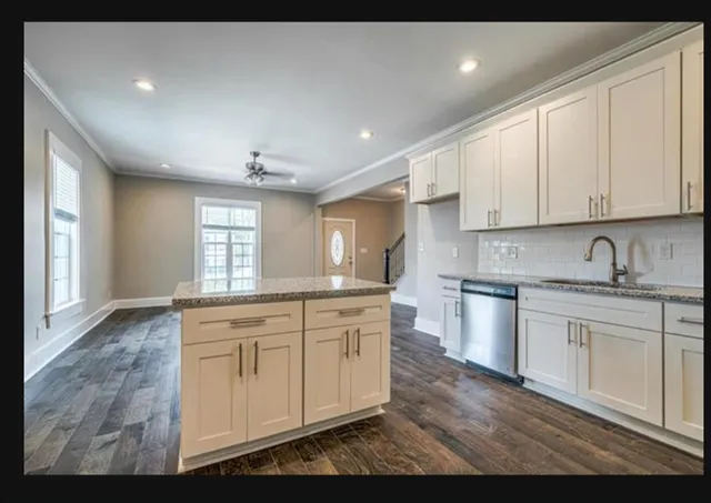 a kitchen with granite countertop white cabinets and white appliances