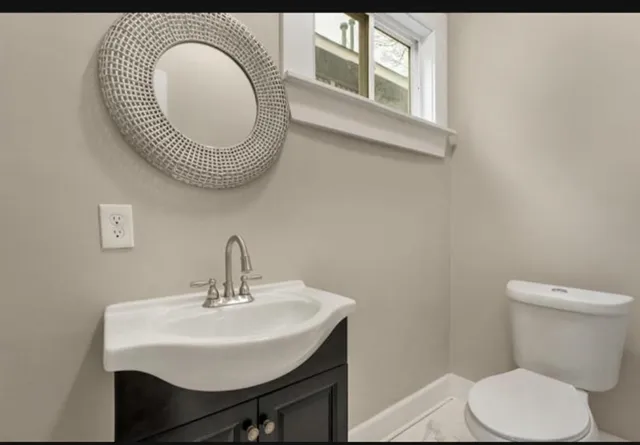 a bathroom with a toilet a sink and a mirror
