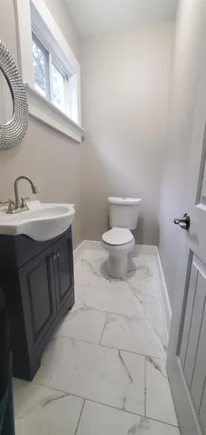 a bathroom with a toilet sink and mirror