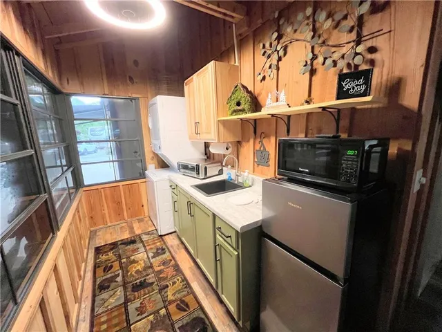 a kitchen with granite countertop a sink and a refrigerator