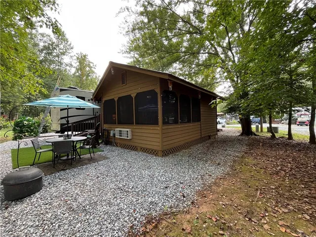 a view of a house with a big yard and sitting area