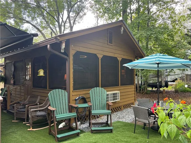 a view of a park with large trees and a wooden fence