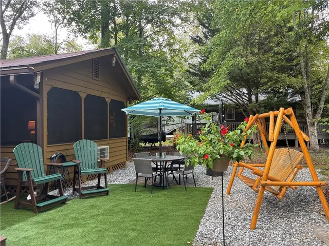 an outdoor view of patio with a table and chairs under an umbrella