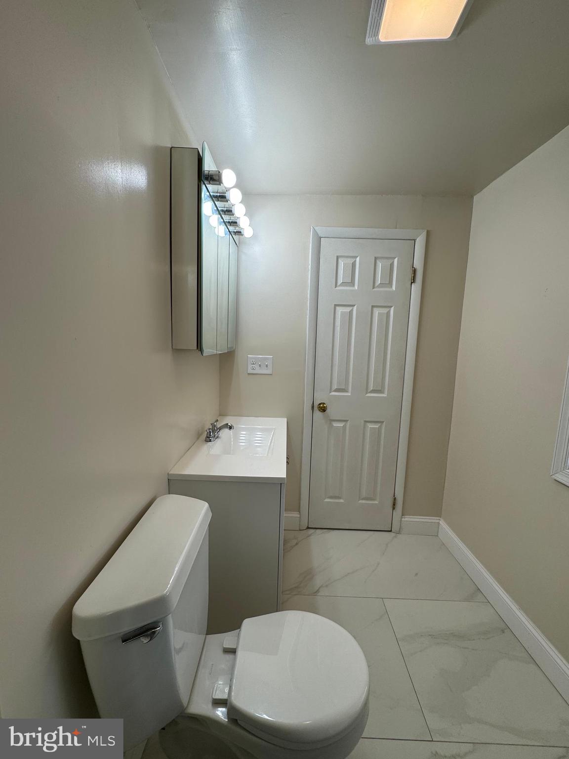 50 Broadship Road Dundalk, MD 21222 - Photo 25 of 30 a white toilet sitting next to a bathroom sink and a mirror