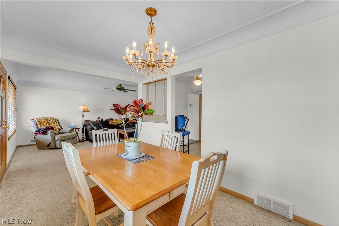 3023 Norris Avenue Cleveland, OH 44134 - Photo 11 of 41 Dining area featuring a chandelier with crystal accents, light-colored walls, and carpeting