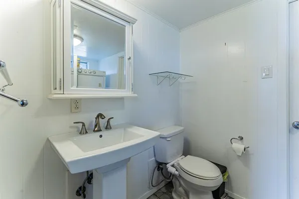 a bathroom with a sink mirror and toilet