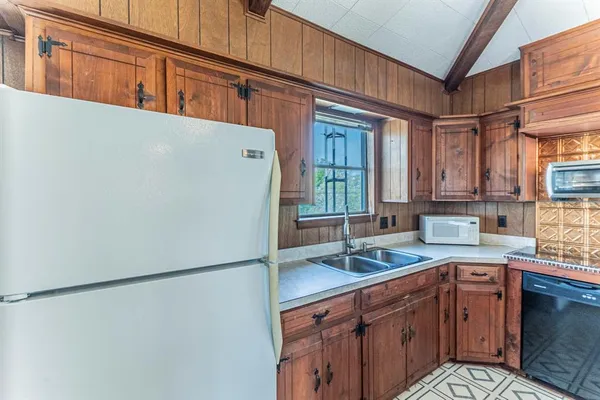 a kitchen with a refrigerator sink and cabinets