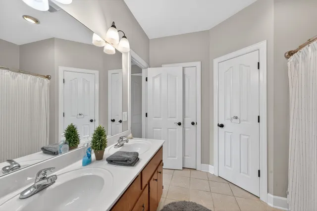 a bathroom with a granite countertop sink a light fixture and a mirror