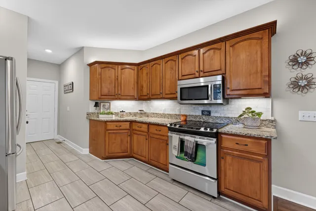a kitchen with stainless steel appliances granite countertop a stove top oven microwave and cabinets