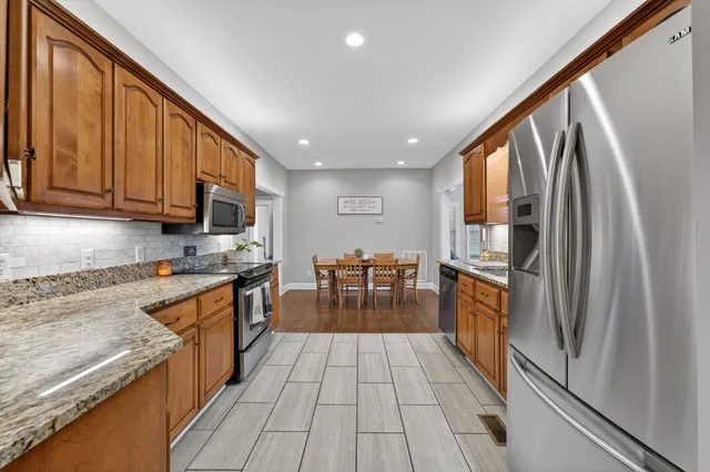 a kitchen with stainless steel appliances granite countertop a refrigerator stove top oven and sink