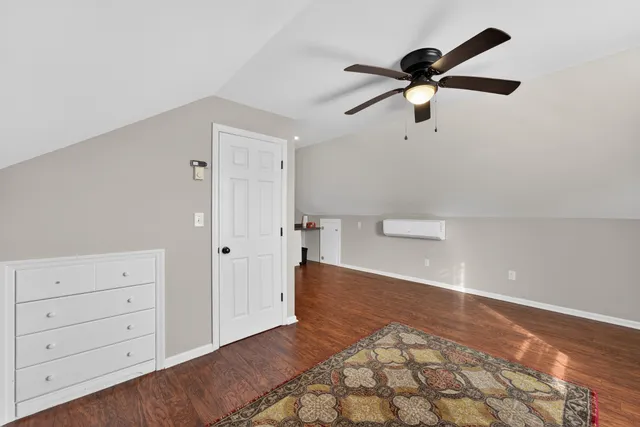 a view of a room with a ceiling fan and wooden floor