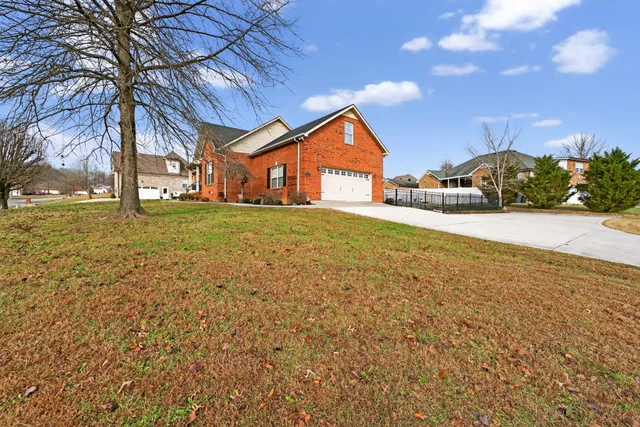a front view of a house with a yard and trees