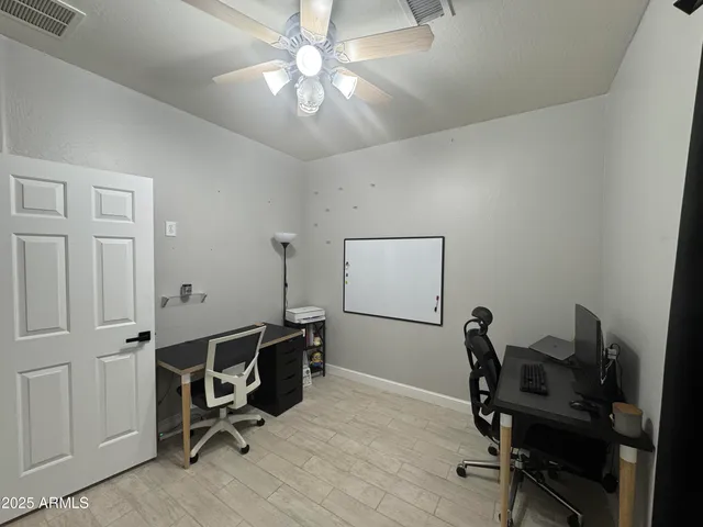 a view of a workspace with furniture and a window