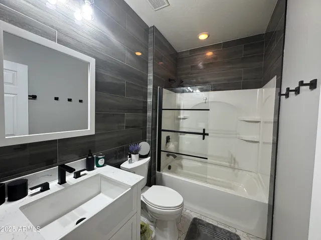 a bathroom with a sink toilet vanity and shower