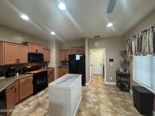 a large kitchen with kitchen island a sink stainless steel appliances and cabinets