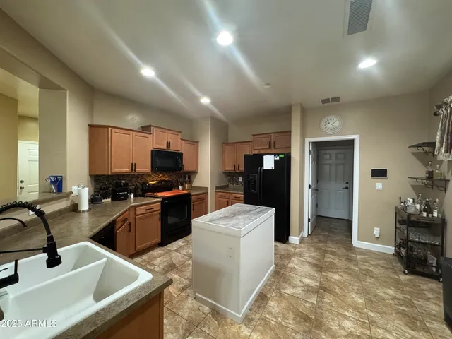 a kitchen with granite countertop a sink stove and refrigerator