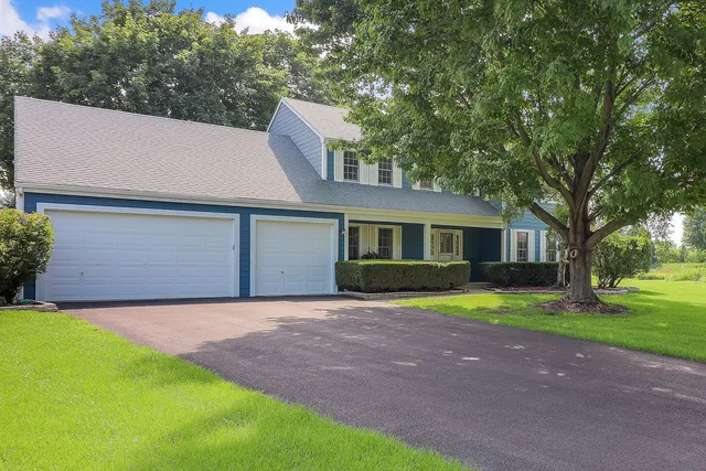 a front view of a house with a garden and trees