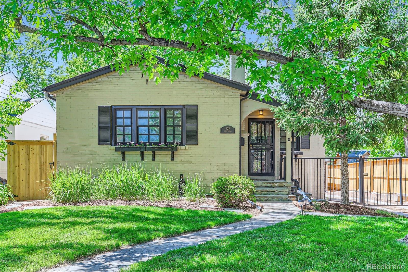 753 Cherry Street Denver, CO 80220 - Photo 1 of 37 a backyard of a house with potted plants and large tree