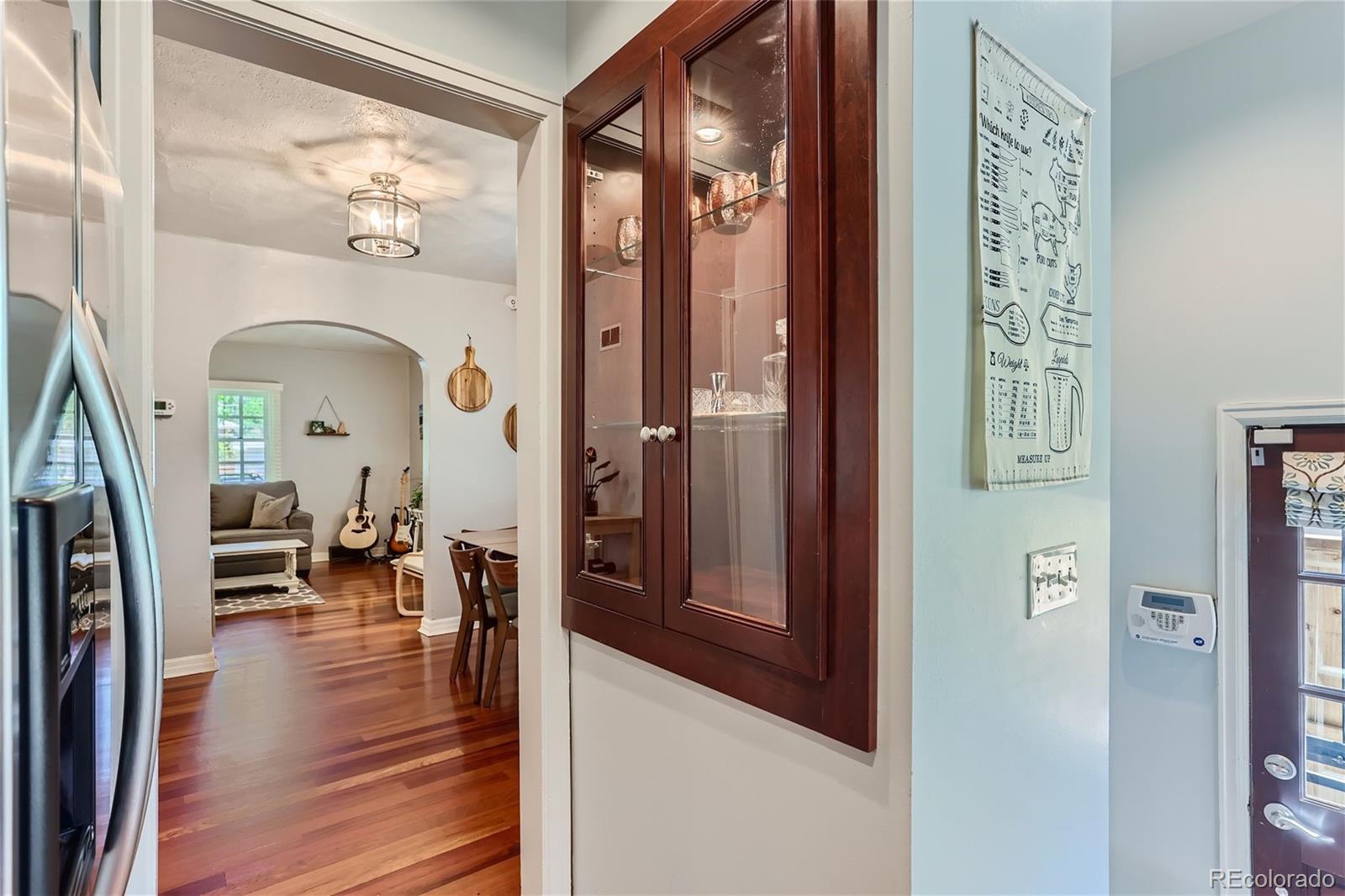 753 Cherry Street Denver, CO 80220 - Photo 14 of 37 a view of a hallway with couches and dining table with wooden floor