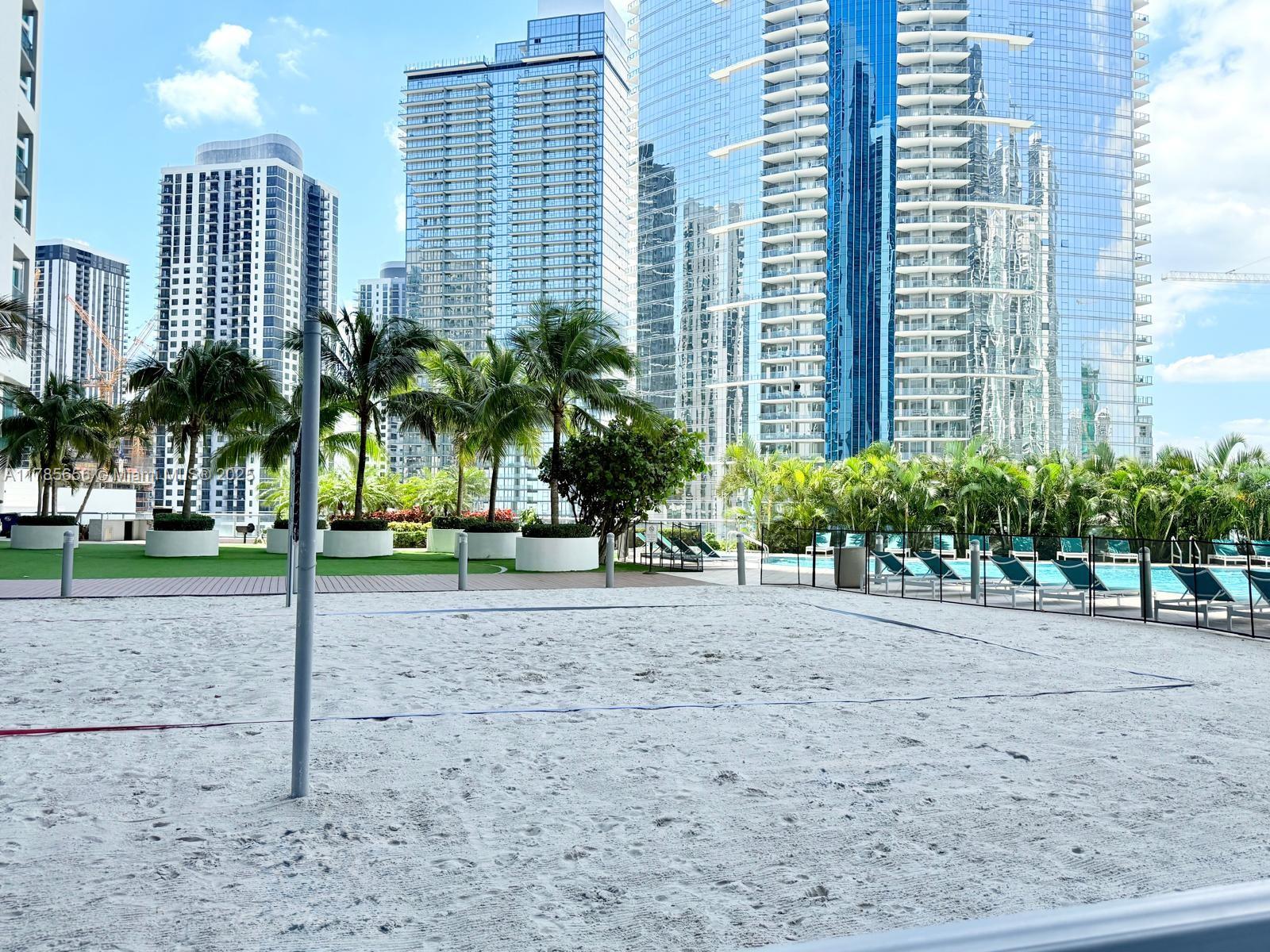 888 Biscayne Boulevard, Unit 1009 Miami, FL 33132 - Photo 11 of 15 a view of a house with a yard and lawn chairs