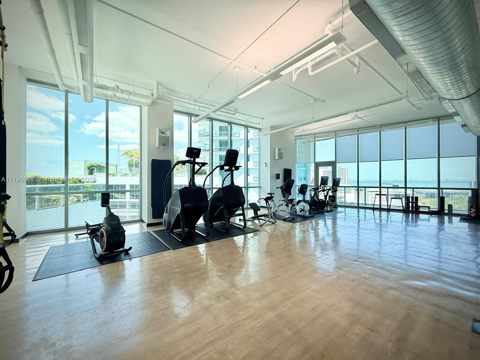 888 Biscayne Boulevard, Unit 1009 Miami, FL 33132 - Photo 12 of 15 a living room with furniture floor to ceiling window and a table