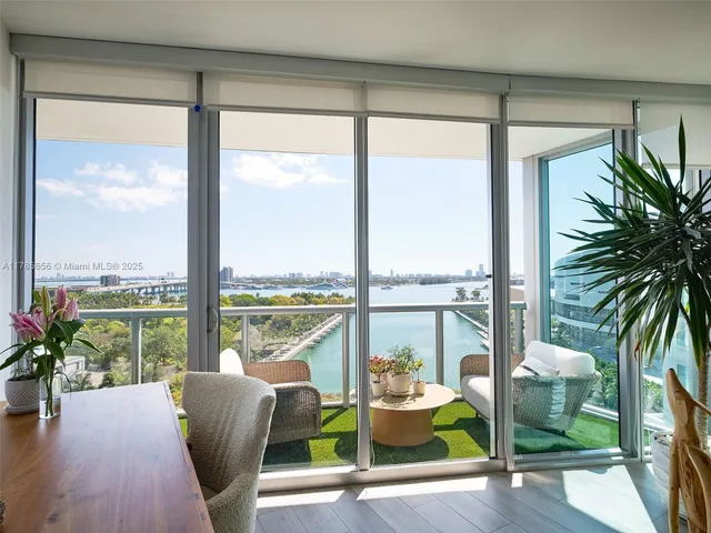 a living room with furniture and floor to ceiling windows