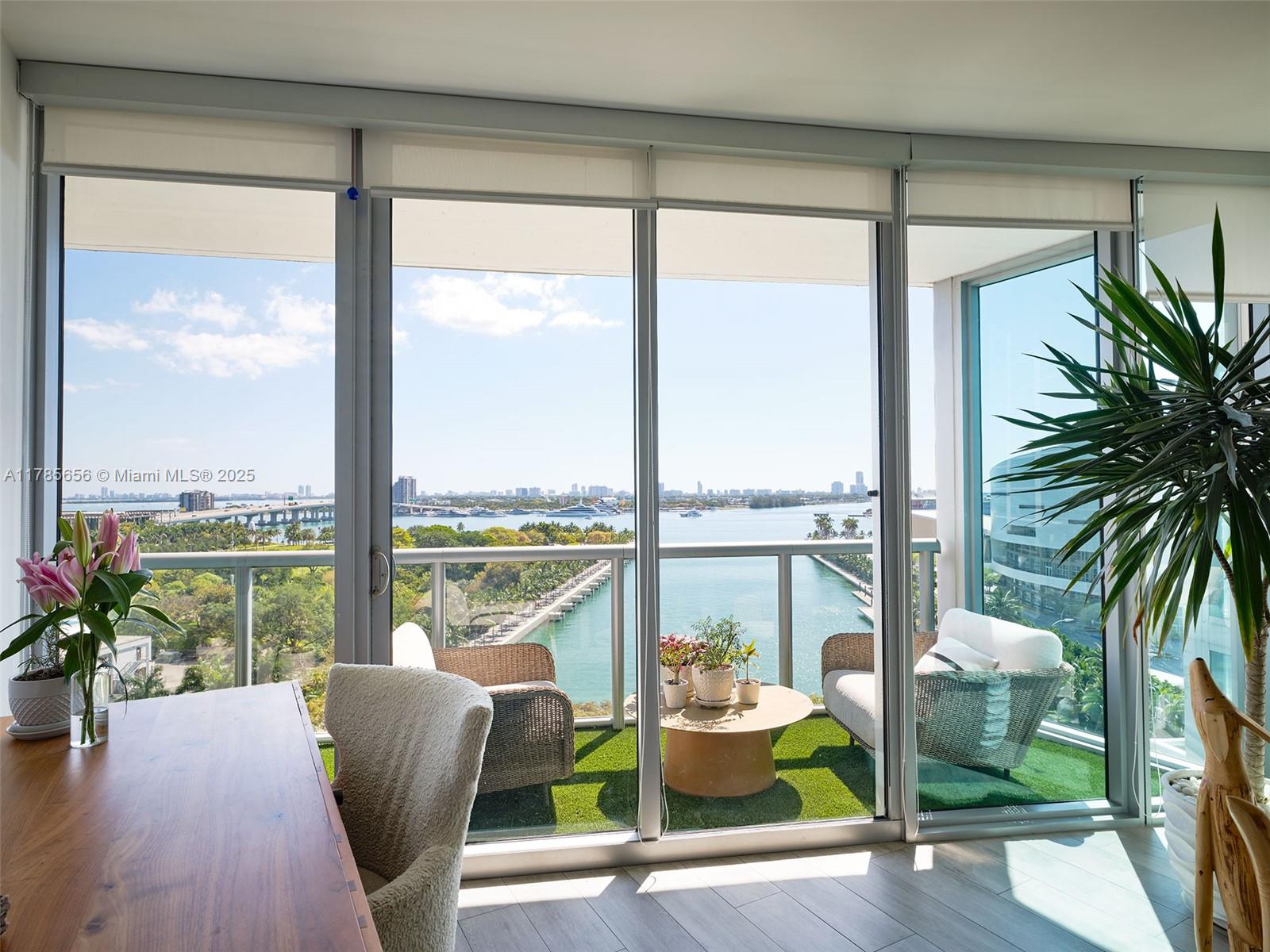 888 Biscayne Boulevard, Unit 1009 Miami, FL 33132 - Photo 2 of 15 a living room with furniture and floor to ceiling windows