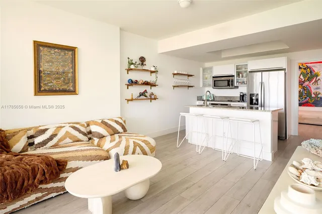 a living room with furniture and kitchen area