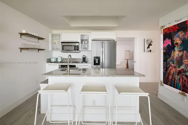 a living room with stainless steel appliances furniture a fireplace and a flat screen tv