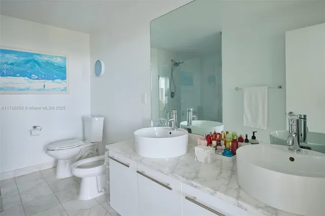 a bathroom with a granite countertop sink mirror and toilet