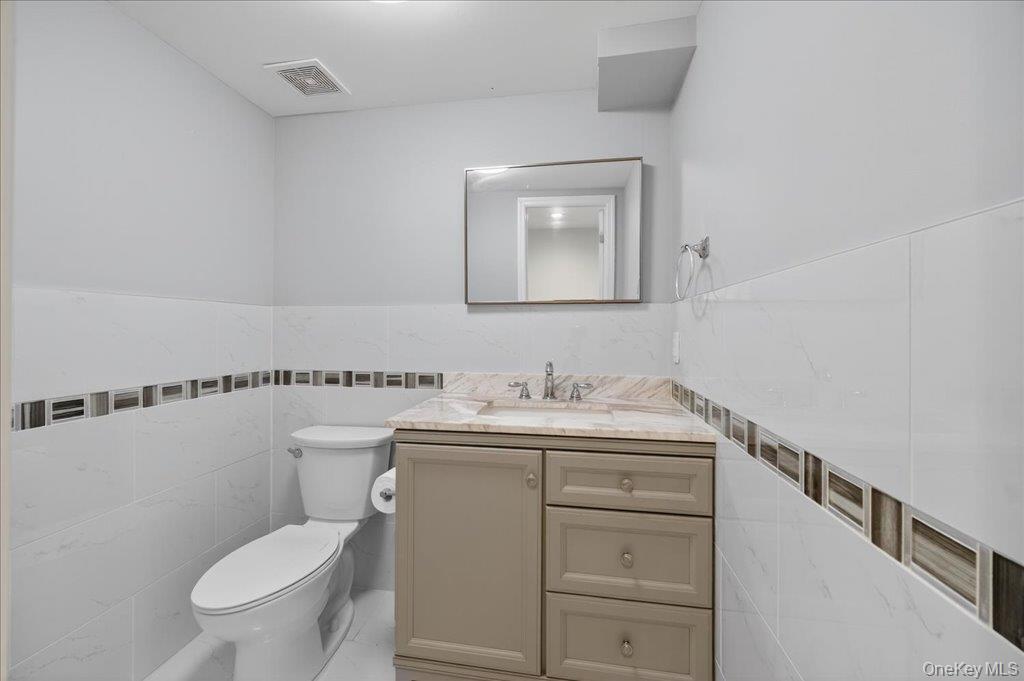 431 Gate Hill Coop Road Stony Point, NY 10980 - Photo 15 of 41 Half bath with tile walls, vanity, and a wainscoted wall