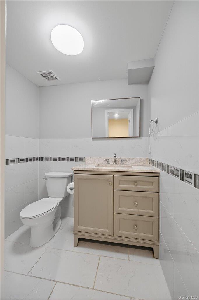 431 Gate Hill Coop Road Stony Point, NY 10980 - Photo 25 of 41 Bathroom featuring tile walls, vanity, wainscoting, and light marble finish floors