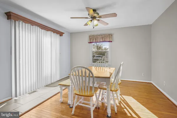 a dining room with wooden floor and stainless steel appliances