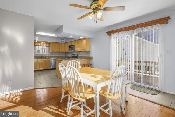 a living room with stainless steel appliances kitchen island granite countertop furniture and a dining table