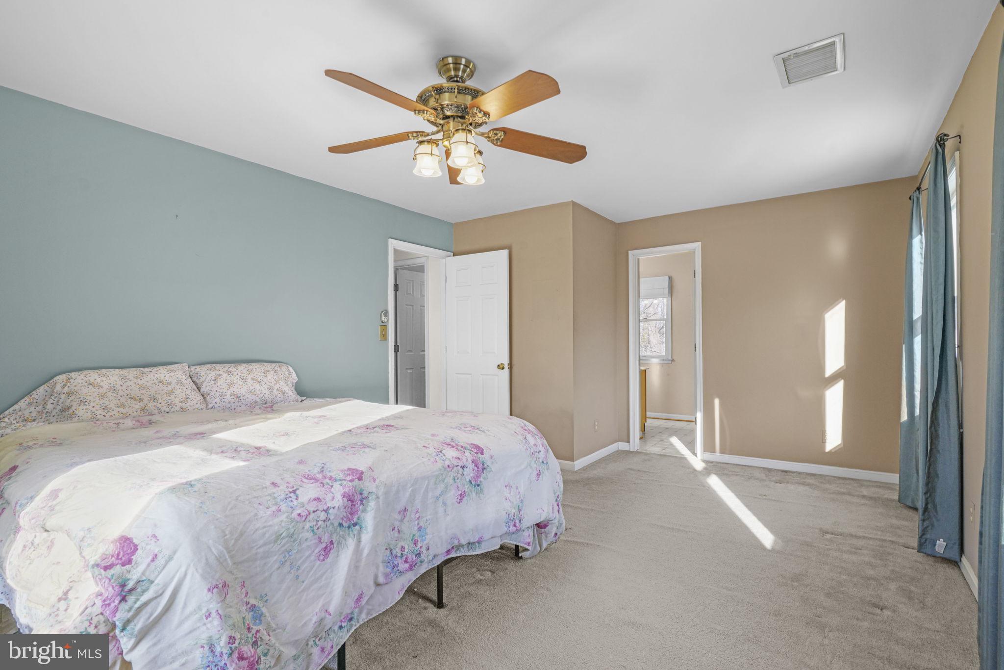 939 Main Street Deale, MD 20751 - Photo 23 of 37 a spacious bedroom with a bed and a chandelier