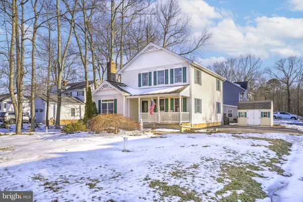 a front view of a house with a yard covered with snow
