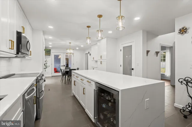 a view of a dining room and livingroom with furniture wooden floor a chandelier