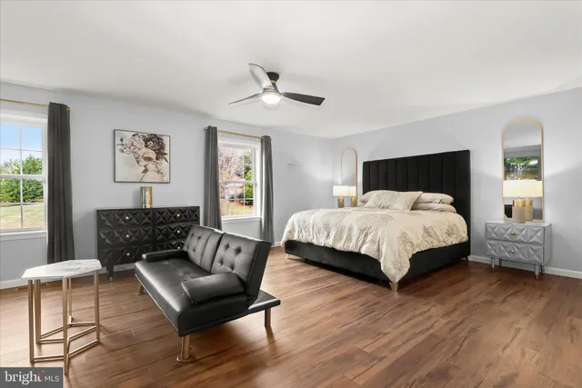 a bedroom with a bed a couch and large window