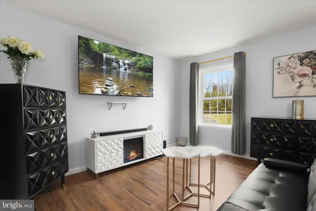 a living room with couches bookshelf and a flat screen tv